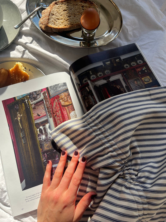 breakfast in bed setting with a striped ruched napkin, soft boiled eggs and toast